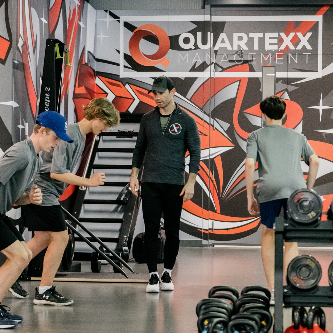 Andy O'Brien overlooking athletes doing bodyweight exercises at the gym