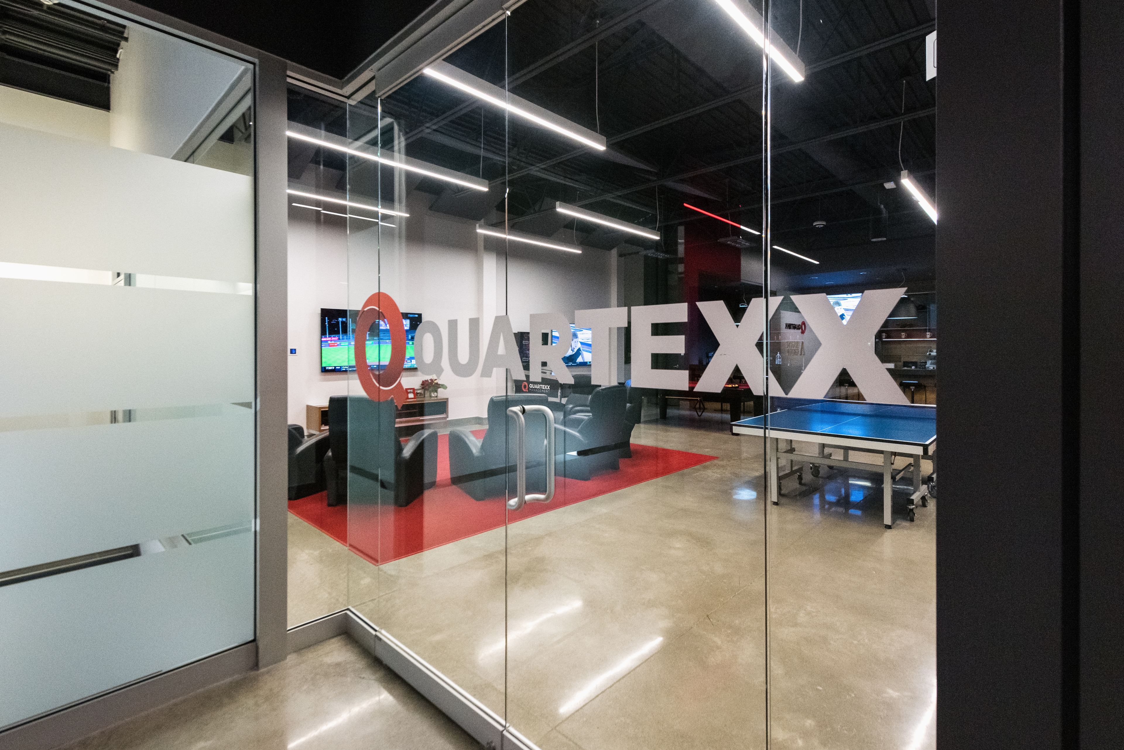 A photo of the Quartexx office lounge taken through the glass doors that has the Quartexx logo on them